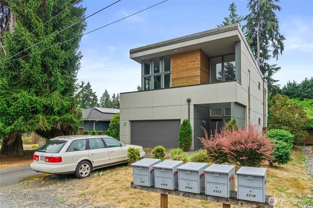 a front view of a house with a garden and parking