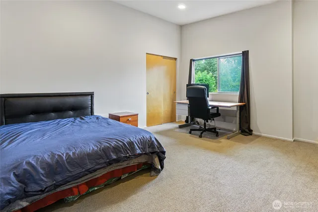 a bedroom with a bed a table and a window