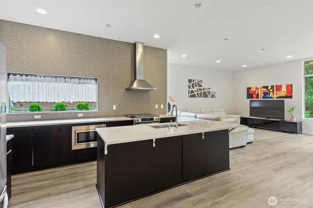 a large kitchen with stainless steel appliances a sink and a stove top oven