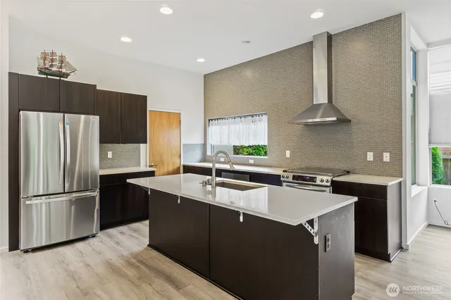 a kitchen with a sink a refrigerator and a stove top oven