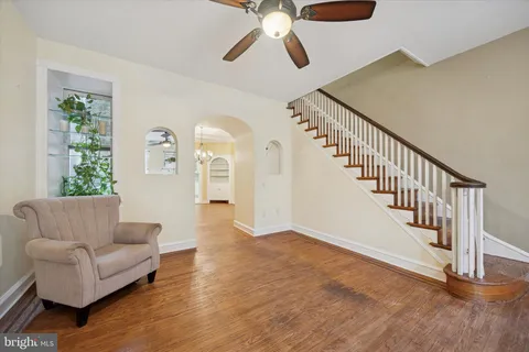 a living room with furniture and entryway with wooden floor