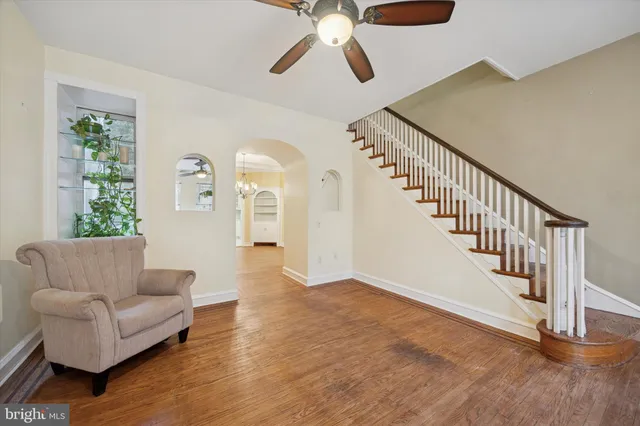 a living room with furniture and entryway with wooden floor