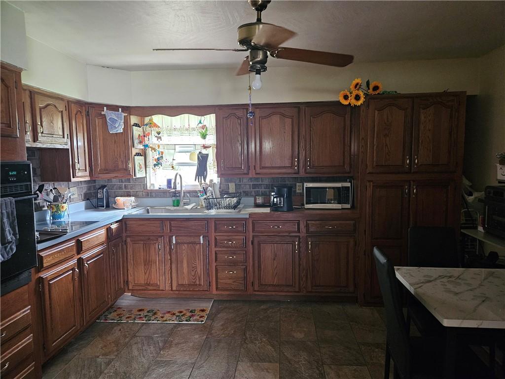 521 West Butler Street Mercer, PA 16137 - Photo 7 of 23 a kitchen with granite countertop wooden cabinets and a sink
