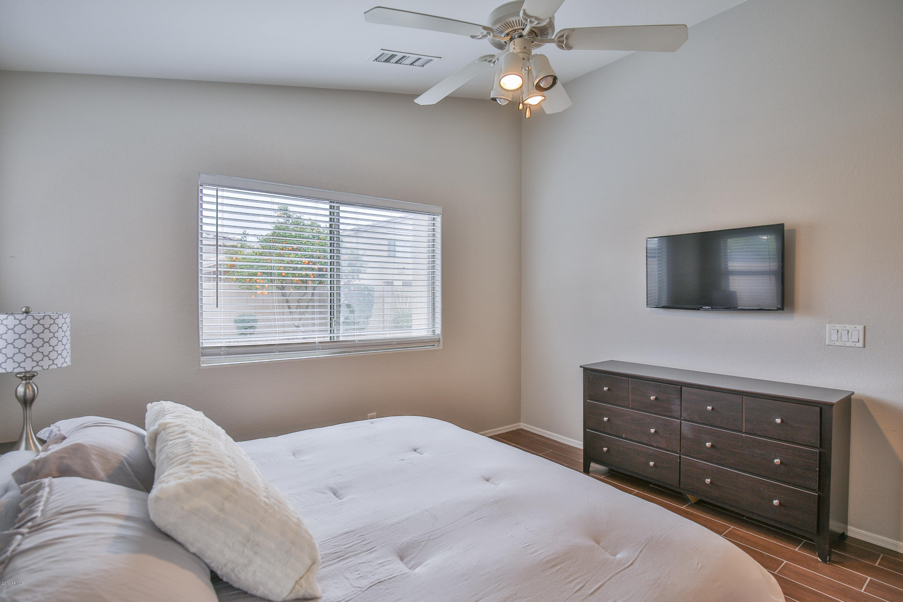 4328 South Rim Court Gilbert, AZ 85297 - Photo 17 of 36 a bedroom with a bed and a flat tv screen on dresser