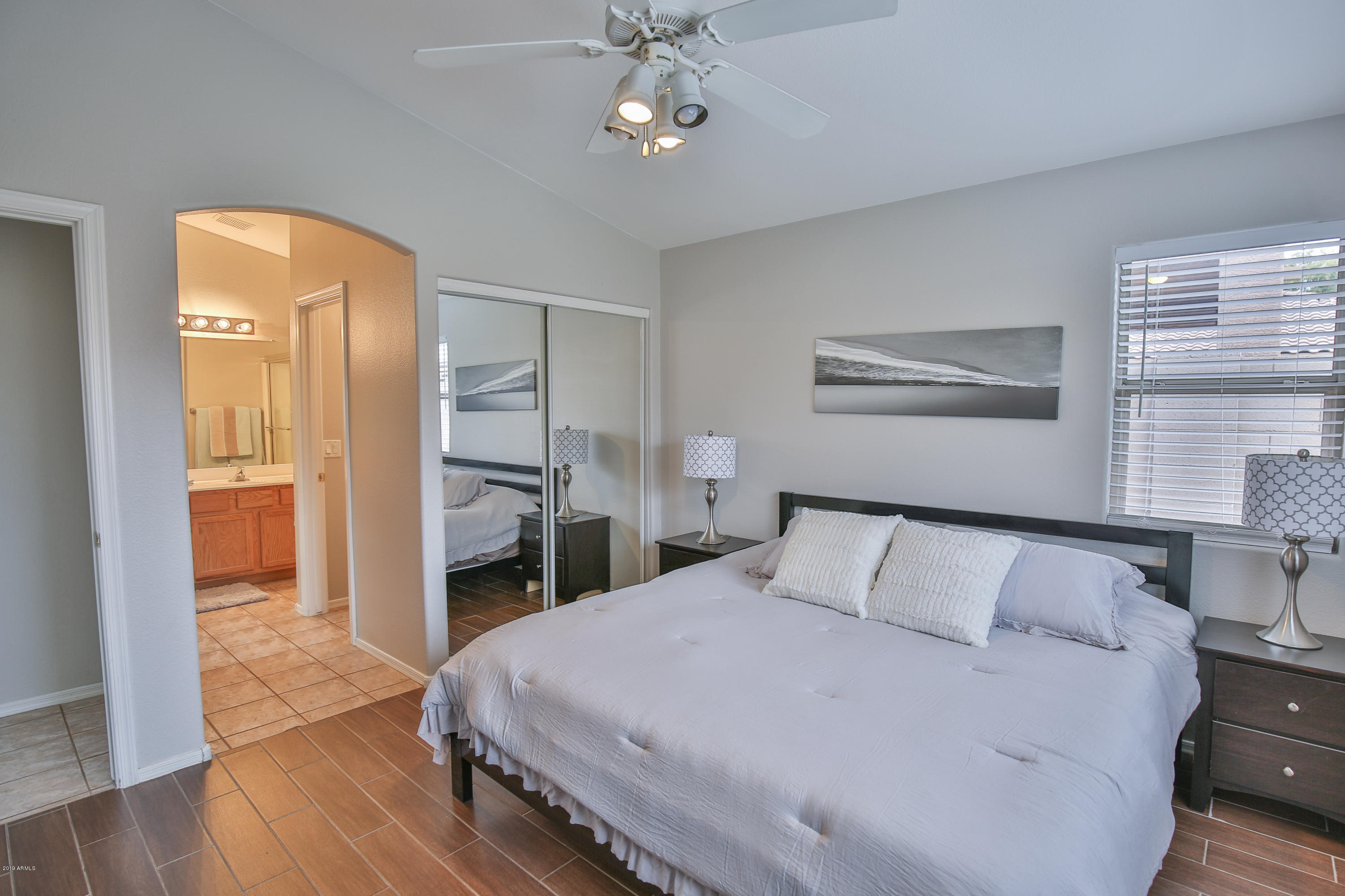 4328 South Rim Court Gilbert, AZ 85297 - Photo 3 of 36 a bedroom with a large bed and a chandelier