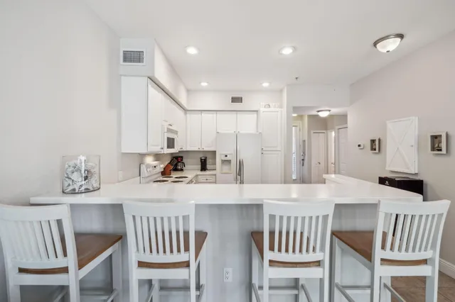 a kitchen with kitchen island a table chairs sink and cabinets