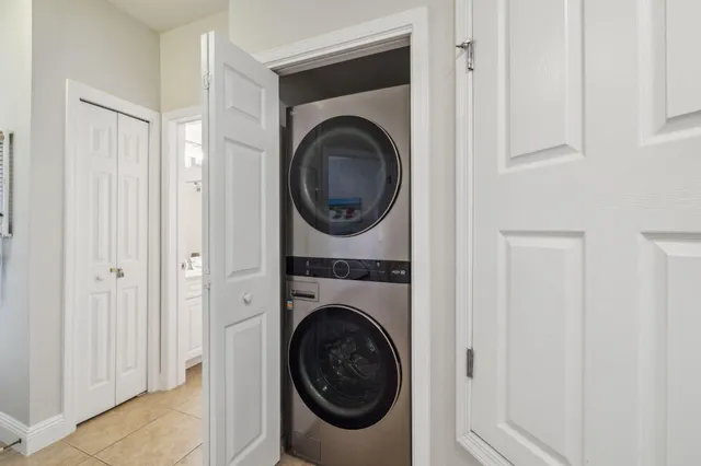 a utility room with dryer washer and a view of bedroom