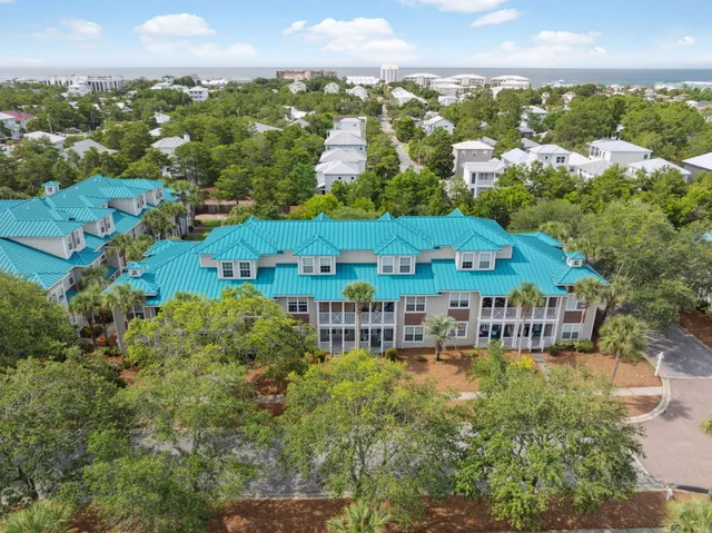 an aerial view of a house with a garden and lake view