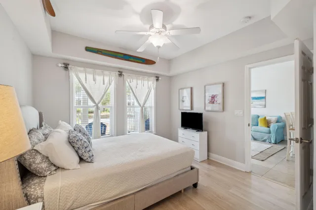 a bedroom with a bed a window and a flat screen tv