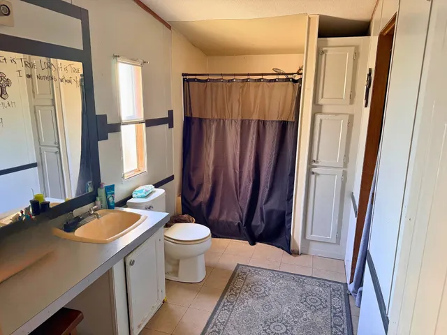 a bedroom with a bed and dresser with mirror