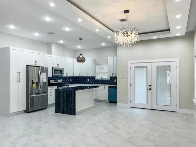 a kitchen with stainless steel appliances kitchen island a large island in the center and a sink