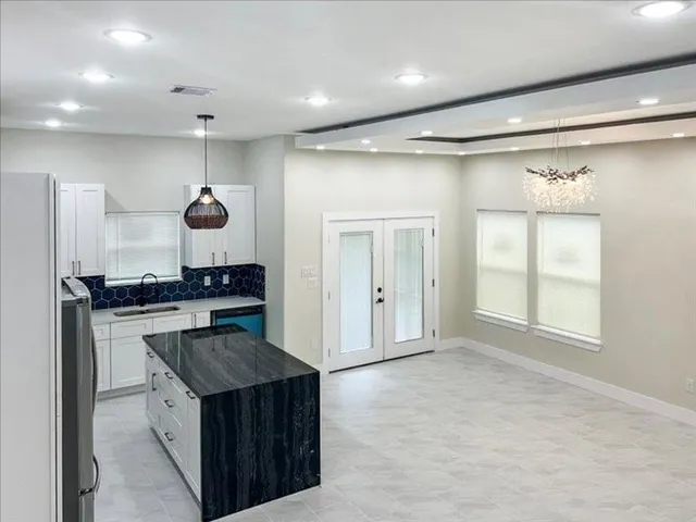 a bathroom with granite countertop double vanity sink and a mirror
