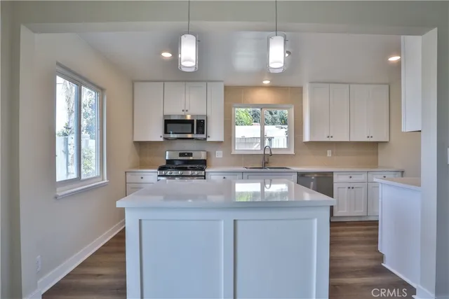 a kitchen with granite countertop a sink and a stove top oven