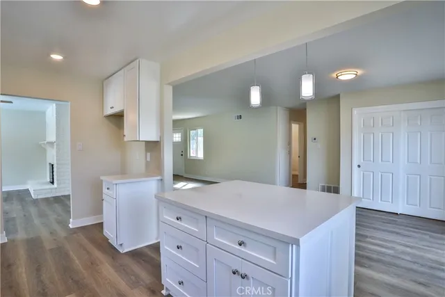 a kitchen with white cabinets and sink