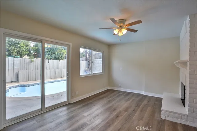 a view of a livingroom with wooden floor and a fireplace