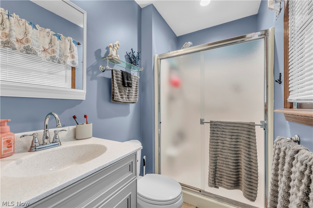 408 River Road Canal Fulton, OH 44614 - Photo 23 of 42 Bathroom featuring a white vanity with integrated sink, chrome faucet, and a framed mirror
