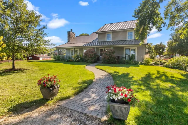 a view of a house with swimming pool lawn chairs and a yard