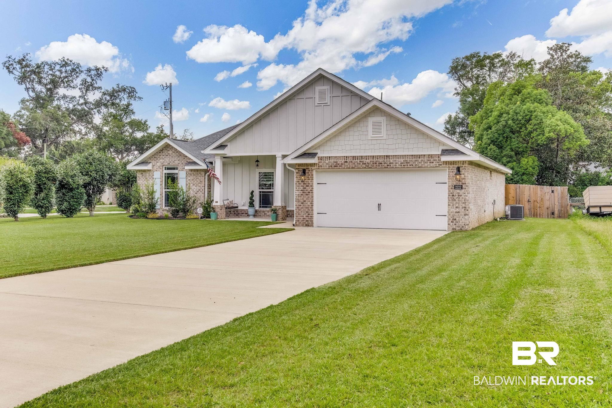 2222 Club House Drive Lillian, AL 36549 - Photo 2 of 49 Craftsman-style house featuring board and batten siding, driveway, a garage, brick siding, and a porch