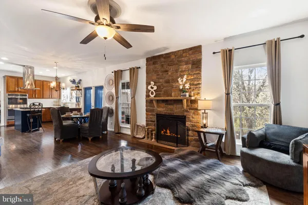 a living room with furniture a fireplace and a chandelier