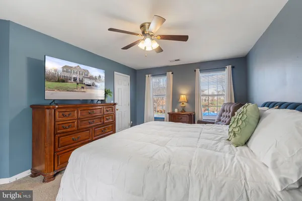 a bedroom with a bed and a mirror on the dresser