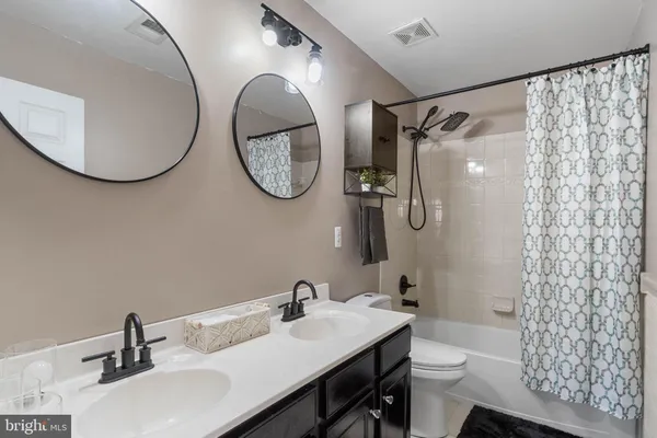 a bathroom with a sink a toilet and a mirror