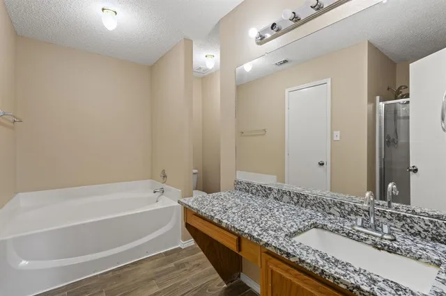 a bathroom with a granite countertop tub and a sink