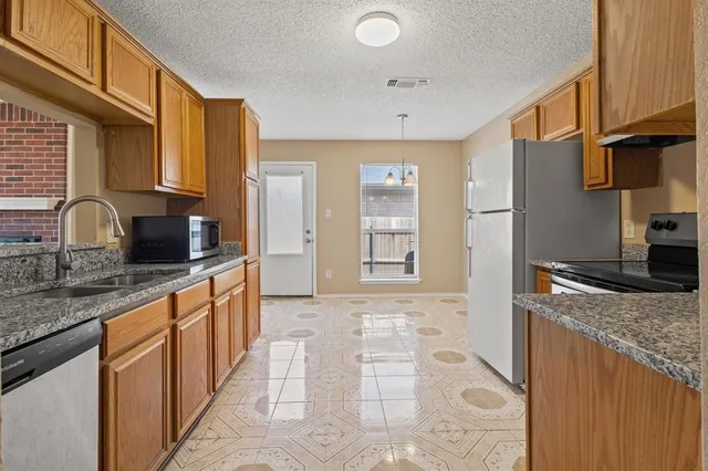a kitchen with granite countertop a sink and a stove top oven