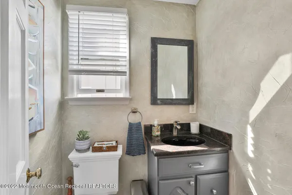 a bathroom with a sink toilet and window