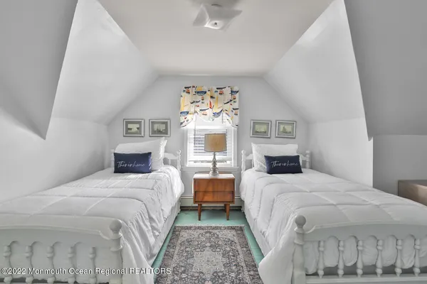 a bedroom with two beds and a chandelier