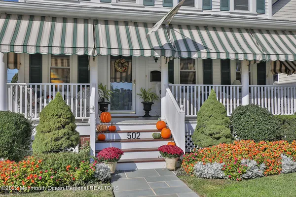a view of a house with a flower garden and wooden fence