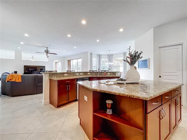 a kitchen with granite countertop a sink and a wooden cabinets