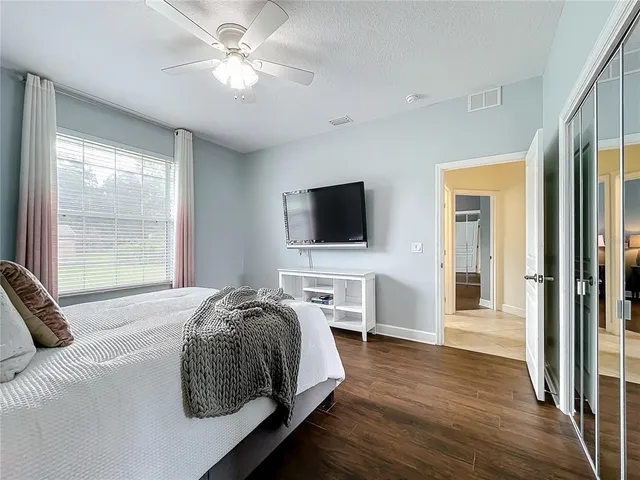 a bedroom with a bed and a ceiling fan