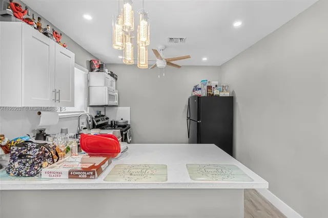 a view of kitchen with kitchen island microwave and stove