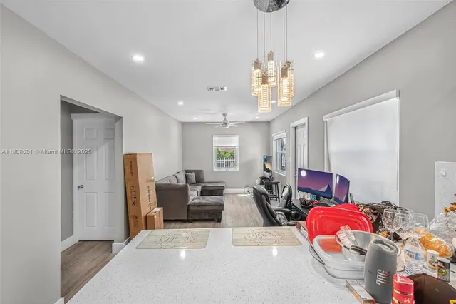 a living room with furniture dining table and a chandelier