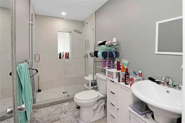 a bathroom with a sink a toilet and shower