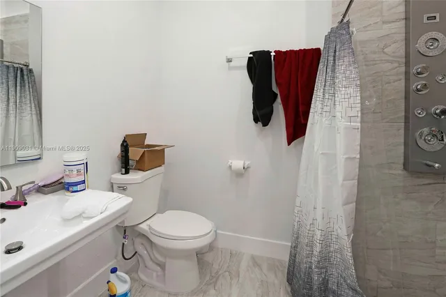 a bathroom with a toilet sink and shower curtain