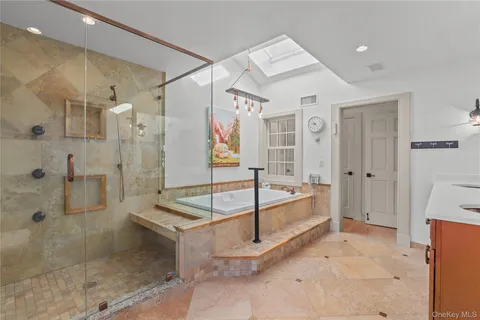 a spacious bathroom with a granite countertop tub shower and mirror