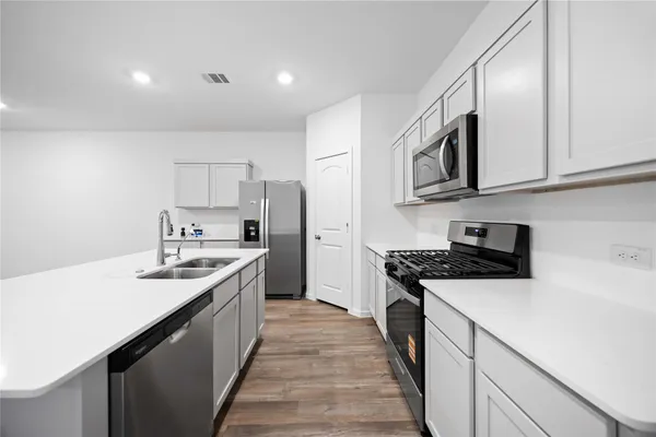 a kitchen with stainless steel appliances granite countertop a sink stove and refrigerator