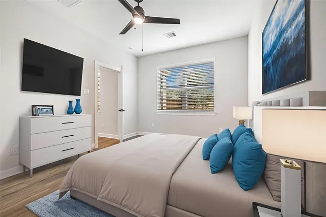 a bedroom with a bed and a flat tv screen on dresser