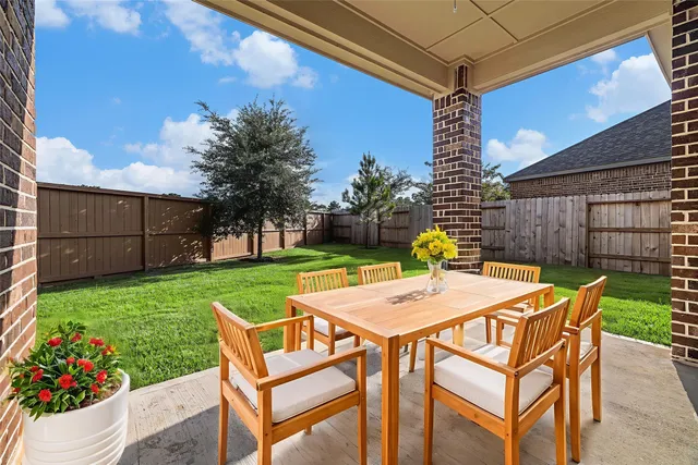a view of a backyard with table and chairs and a barbeque