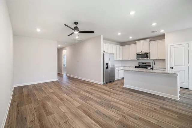 a view of kitchen with refrigerator microwave and stove top oven
