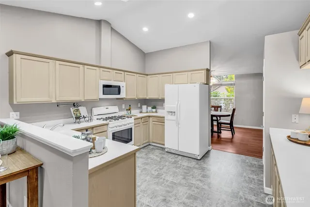 a view of kitchen with refrigerator stove microwave and cabinets