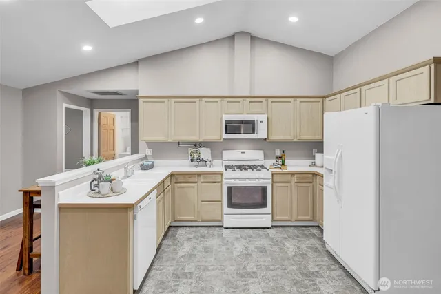 a kitchen with a sink a stove a refrigerator and white cabinets