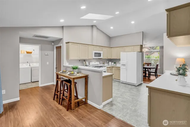 a kitchen with stainless steel appliances granite countertop a refrigerator a stove and a wooden floors