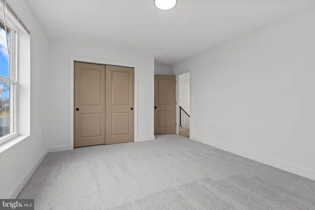 an empty room with an entryway and window