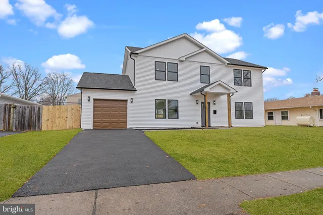 a front view of a house with a garden and yard