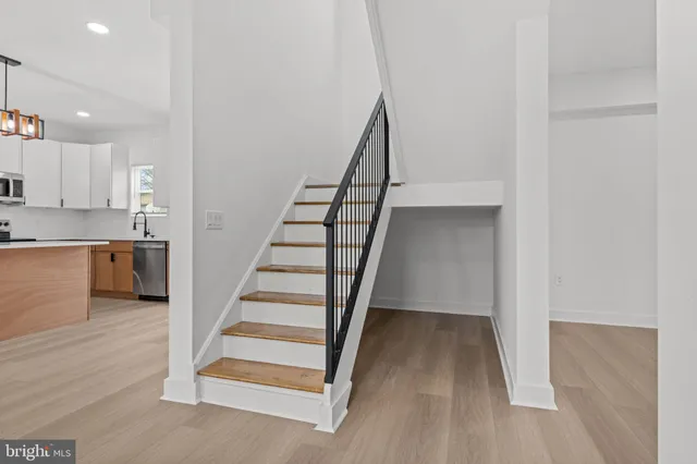 a view of entryway and kitchen with wooden floor