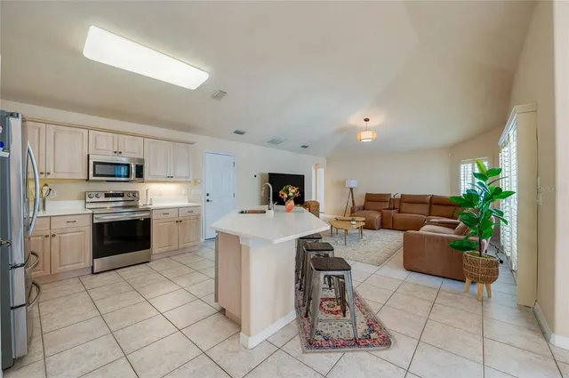 a kitchen with kitchen island a counter top space a sink stainless steel appliances and cabinets
