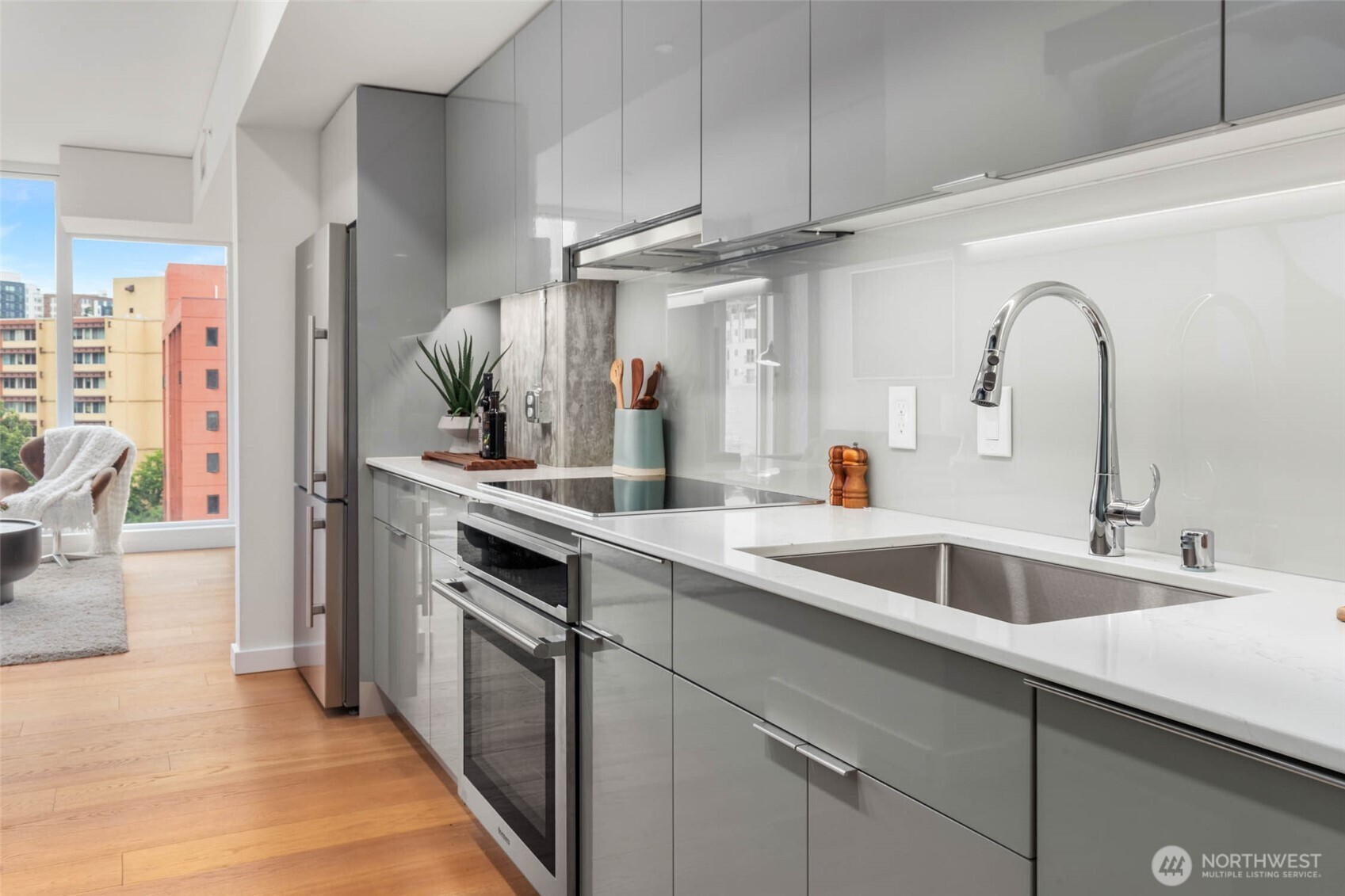 450 South Main Street, Unit 903 Seattle, WA 98104 - Photo 8 of 25 a kitchen with stainless steel appliances granite countertop a sink and cabinets