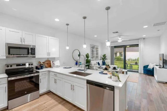 a kitchen with stainless steel appliances granite countertop a sink and a refrigerator
